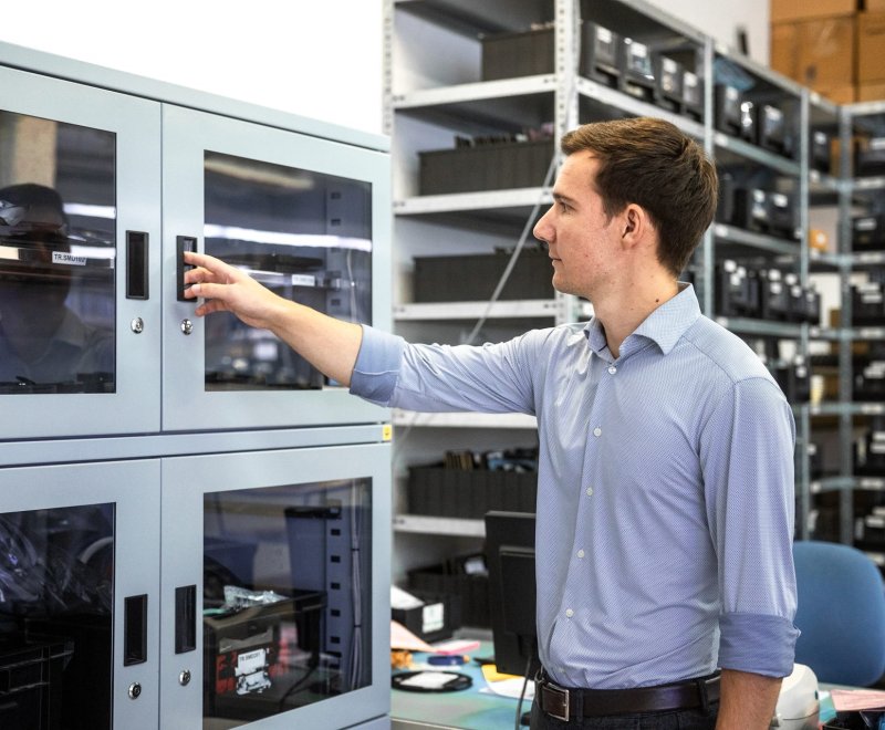 Mitarbeiter am Trockenschrank für feuchteempfindliche Bauteile